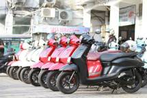 A lineup of colorful motor scooters parked outdoors at a service area, showcasing modern design. (Foto: Jepret Pret / Pexels)