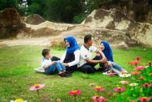 A joyful family picnic in a green park, enjoying nature and togetherness. (Foto: Henry Suwardi / Pexels)