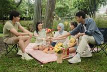 Cheerful family having a picnic in a lush Jakarta park with food and fun. (Foto: Alfatah Bilal Afdam / Pexels)