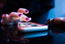 person using black smartphone with gray and pink case (Foto: Rob Hampson / Unsplash)