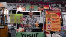 Asian street food vendor preparing telur gulung in a busy market stall. (Foto: Sogi . / Pexels)
