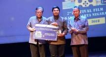 Ketua Dewan Juri, Slamet Rahardjo (kiri) dan Ketua BPK, Prof, Moermahadi memberikan tropi kepada M. Fadel Pratama (tengah) dalam Festival film Kawal Harta Negara