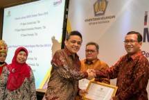 Direktur Jenderal Pengelolaan Pembiayaan dan Risiko Kementerian Keuangan RI Luky Alfirman, Direktur Surat Utang Negara (SUN) Kementerian Keuangan RI Loto Srinaita Ginting serahkan penghargaan ke Direktur Keuangan Bank BRI Haru Koesmahargyo