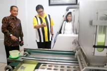 Menteri Perindustrian Airlangga Hartarto didampingi Dirjen Industri Kecil dan Menengah (IKM) Gati Wibawaningsihdan Kepala Dinas Perindustrian Provinsi Riau, Asrizal memperhatikan proses produksi pembuatan bolu Kemojo di gerai Mimie, Pekanbaru, Riau (
