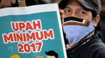 Seorang buruh melakukan aksi mendesak pengesahan UMK 2017. (AFP/Bay Ismoyo via Getty Images)