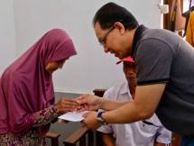 Direktur Human Capital Management Telkom Edi Witjara (kanan) menyerahkan kunci rumah dalam program Bedah Rumah Telkom 2019 kepada Ibu Ratna