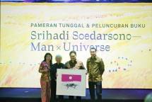 Maestro lukis Srihadi Soerdarsono (kedua kiri) menyerahkan litografi kepada Menteri BUMN RI, Erick Thohir (kedua kanan) didampingi oleh Chairman Coordinator Pameran, Purwaty Lee Couhault (kiri) dan President Director Sugar Group Companies, Gunawan Jusuf (kanan) saat pembukaan Pameran Tunggal &ldquo;SRIHADI SOEDARSONO&ndash;&ndash; Man x Universe&rdquo; pada Rabu 11 Maret 2020 di Galeri Nasional Indonesia, Jakarta.