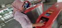 Seorang karyawati menggunakan kartu Jak Lingko Bank DKI untuk pembayaran di gate transportasi umum.