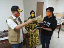  Letjen TNI Doni Monardo mengipasi lilin di atas kue ulang tahun yang dipegang putranya disaksikan sang istri.