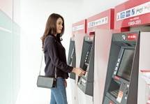 Nasabah Bank DKI melakukan transaksi di ATM