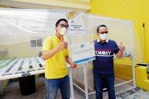 Business Unit Head WOM Finance Regional Jakarta Bogor Depok Bekasi (Jabodebek), Gilbert Samuel Siahaan (kanan) berpose bersama staff Yayasan Pita Kuning di depan rangkaian media tanam hidroponik. (Foto: Humas WOM Finance)