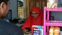 Nasabah BRI menggunakan MBanking untuk pembayaran secara QRIS