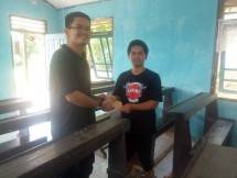 Wesly Altie Hasibuan, Manager Plasma, Perizinan, Komunikasi dan CSR PT Sawit Mandiri Lestari menyerahkan bantuan untuk perayaan Natal di Gereja Kalimantan Evangelis (GKE) Desa Riam Penahan, Kalimantan Tengah. (Foto: Humas PT Sawit Mandiri Lestari)