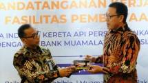 Direktur Utama PT Bank Muamalat Indonesia Tbk Achmad K. Permana (kanan) menerima miniatur bus listrik dari Direktur Utama PT Industri Kereta Api atau PT INKA (Persero) Budi Noviantoro (kiri) pada seremoni penyaluran pembiayaan di Muamalat Tower, Jakarta.