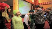 Menperin Airlangga Hartarto mengalungkan medali kepada wisudawan SMK Padang (Foto Humas)