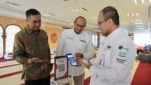 Direktur Operasi PT Bank Muamalat Indonesia Tbk Wahyu Avianto (kanan) didampingi oleh Direktur Kepatuhan Karno (kiri) dan Chief Human Capital Officer Riksa Prakoso (tengah) melakukan donasi menggunakan fitur QR Code pada aplikasi Muamalat DIN di kotak amal Masjid Al-Muamalah, Muamalat Tower, Jakarta
