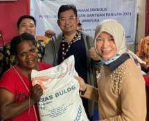 (kanan) Direktur Bisnis Kurir dan Logistik Pos Indonesia, Siti Choiriana menyerahkan bantuan kepada Penerima Bantuan Pangan (PBP) di Kelurahan Yabansai, Kecamatan Heram, Kota Jayapura,