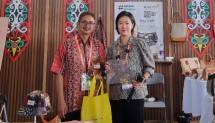Manager Digitalisasi & Monetasi UMK Telkom, Achmad Retno Syafarie (kiri) bersama pengunjung yang membeli produk batik bag dari Soko Craft Pekalongan dalam gelaran China-ASEAN Expo di Nanning International Convention and Exhibition Center (NICE), yang berlokasi di kota Nanning, Guangxi, China beberapa waktu lalu