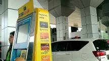 Pengguna jalan tol menempelkan kartu e money di gardu tol.
