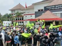 Para buruh PT Teodore Pan Garmindo (TPG) berkumpul di depan kantor Pemda Kabupaten Tasikmalaya untuk mengadukan nasib mereka karena belum mendapat upah selama 1 bulan dan kelangsungan pekerjaan terganggu akibat konflik antara pemegang saham. (Foto: Humas TPG)