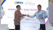 Anggota Badan Pelaksana Badan Pengelola Keuangan Haji (BPKH) Harry Alexander (kanan) dan Direktur Utama PT Bank Muamalat Indonesia Tbk Indra Falatehan (kiri) berfoto dengan memegang mockup Perjanjian Kerja Sama (PKS) layanan umrah, haji plus dan pelunasan haji kepada jemaah daftar tunggu di Jakarta