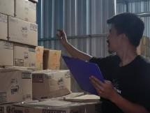 Pekerja mencatat jumlah stok barang