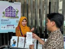 Seorang nasabah melihat brosur produk KPR Hijrah di kantor cabang PT Bank Muamalat Indonesia Tbk di Jakarta. 
