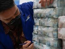 Petugas Bank Mandiri mengecek keuangan yang akan ditukarkan ke masyarakat
