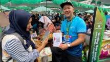 Direktur Finance & Strategy BSI Ade Cahyo Nugroho (kanan) saat melayani translaksi pembayaran QRIS pengunjung pada gelaran acara Sibakul Jogja Sport Fest 2024 di salah satu tenant UMKM yang berlokasi di Stadion Mandala Krida DIY