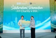 Direktur Utama PT Bank Syariah Indonesia Tbk (BSI) Hery Gunardi (kiri) menyerahkan bantuan sosial kepada Ketua Forum Pemred Retno Pinasti (kanan). 