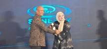 Keterangan foto : Mohamad Sigit, OJK menerima cenderamata dari ceo synergy Partner prima, Revie Fayanti