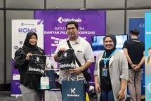 Pengungjung berpose bersama staf KiriminAja di depan booth KiriminAja saat menghadiri KISSC 2025 di SMESCO