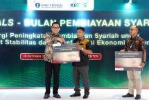 Direktur Retail Banking BSI Kemas Erwan Husainy (kiri) berjabat tangan dengan nasabah saat seremonial business deals Bulan Pembiayaan Syariah dalam rangkaian ISEF 2025 Jakarta. 