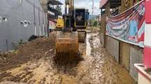 Excavator mengeruk lumpur yang terbawa banjir untuk membuka akses jalan di Kecamatan Nanggalo Korong Gadang, Kota Padang, Minggu (30/11/2025). Kerusakan infrastruktur yang masih menjadi fokus penanganan meliputi jembatan putus, jalan amblas, serta jalur transportasi nasional dan provinsi. Jalur nasional yang masih terputus di antaranya berada di Kota Padang Panjang dan Sicincin. (BPBD/Kemkomdigi)