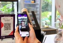 Karyawan melakukan pembayaran menggunakan fitur Quick Response Code Indonesian Standard atau QRIS di aplikasi mobile banking Muamalat DIN