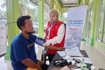 Petugas medis AdMedika dan TelkoMedika melakukan pemeriksaan tekanan darah kepada warga terdampak banjir dan tanah longsor di Mesjid Bandar Mahligai, Desa Bandar Magligai, Kec Sekerak, Aceh Tamiang, Jumat (9/1).