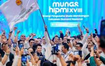 Ade Jona Prasetyo (tengah) memegang bendera setelah terpilih menjadi Ketua BPP HIPMI 