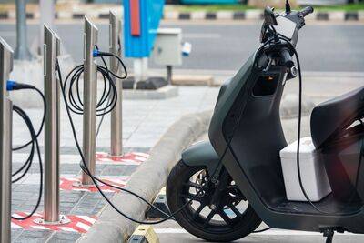 Motor listrik skutik modern di stasiun pengisian, transportasi ramah lingkungan